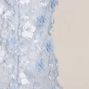 Close-up detail of light blue mesh dress featuring 3D floral appliqués and pearl centers
