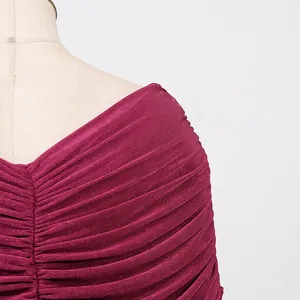Close-up detail of a burgundy pleated bodycon dress with elegant ruching at the neckline.