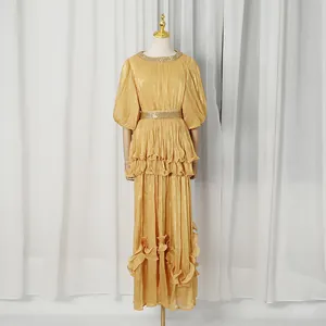 Detail view of gold tiered French retro maxi dress with pleated texture and ruffles