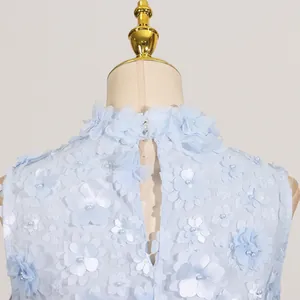 Detailed back view of a light blue dress with 3D floral appliqués and pearl beads