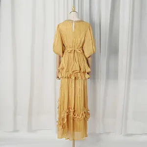 Back view detail of a French retro gold tiered maxi dress with ruffles and waist tie
