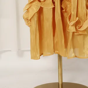 Close-up detail of elegant pleated ruffles on a vintage yellow French court style dress