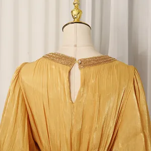 Close-up of French vintage gold pleated dress with elegant beaded collar detail
