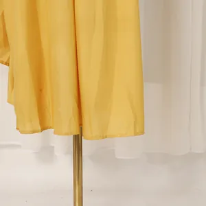 Detail view of the elegant yellow hem on a French retro waisted summer maxi dress