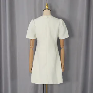 Rückansicht eines eleganten cremefarbenen Tweed-Minikleids im französischen Modestil