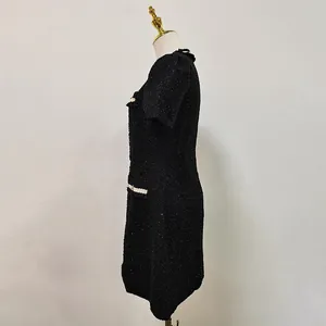 Detailansicht der Seitenansicht eines schwarzen Tweed-Kleides im französischen Stil