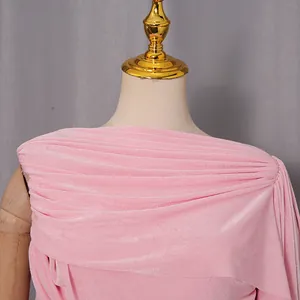 Primo piano di un abito di velluto rosa con elegante dettaglio della scollatura a pieghe.
