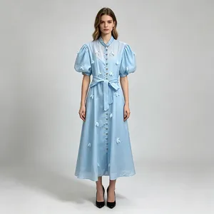Élégante robe longue bleu clair de style français avec patchwork floral et manches bouffantes.