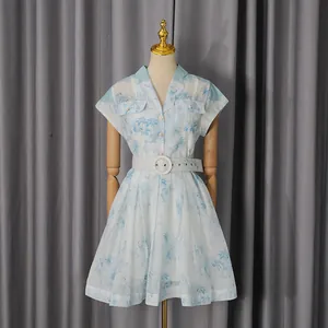 Vue détaillée d'une robe chemise blanche et bleue à imprimé palmier avec ceinture