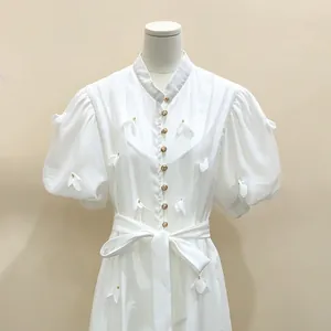Vue détaillée d'une robe blanche de style français avec des fleurs 3D délicates