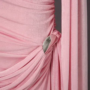 Dettaglio ravvicinato della fibbia in metallo argento su elegante abito rosa arricciato