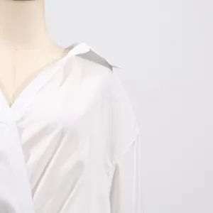 Detailed view of the collar and neckline on a minimalist white V-neck fashion dress