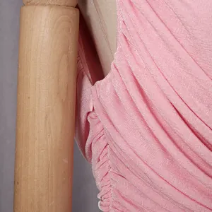Dettaglio dell'abito a pieghe rosa elegante con cerniera laterale a scomparsa e tessuto.