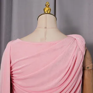 Primo piano dell'elegante trama drappeggiata e dello scollo asimmetrico di questo abito rosa.