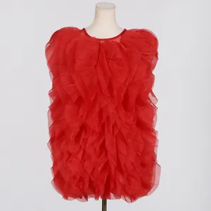 Detail view of a vibrant red sleeveless dress featuring layered ruffle stitching on a mannequin.