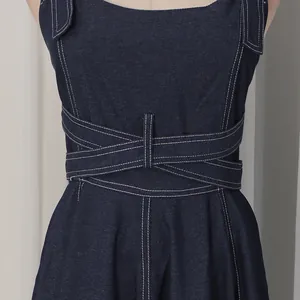 Nahaufnahme eines dunkelblauen Jeanskleides mit Wickeltaille und Kontrastnähten