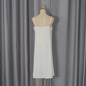 Detailed back view of a minimalist white spaghetti strap slip dress on a mannequin