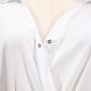 Close-up of snap button closure and V-neck detail on white casual dress