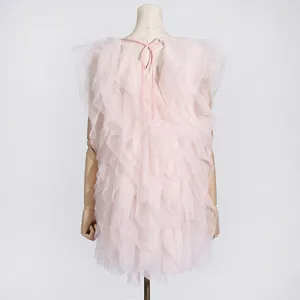 Detailed back view of a sweet pink ruffled tulle mini dress featuring a tie-back design