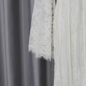 Close-up detail of white floral lace dress sleeve with delicate eyelash lace trim fringe