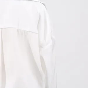 Close-up detail of the white fabric and shoulder seam of a stylish casual dress