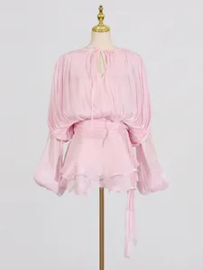Elegante abito a pieghe rosa in stile francese con tessuto luccicante e nastro in vita.