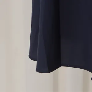 Detailansicht des dunkelblauen Kleidssaums mit feinen Nähten und glattem Stoff.