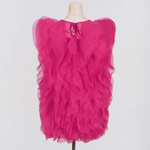 Back view of a hot pink ruffled mini dress with layered textures and a sweet round neck.