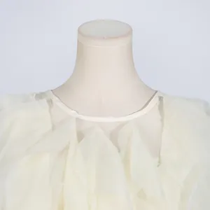 Close-up detail of delicate cream ruffled neckline on a stylish summer mini dress