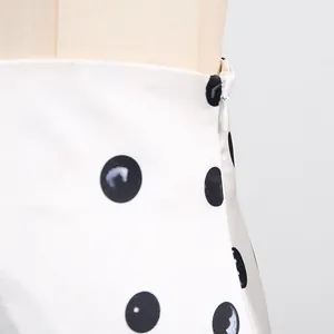 Close-up of white polka dot skirt featuring high waist and hidden zipper detail