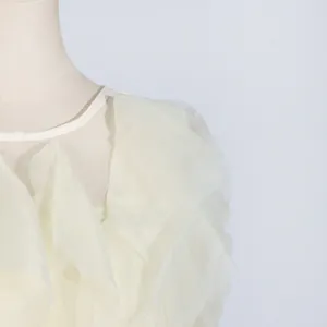 Close-up detail of the elegant layered off-white ruffles on a round neck summer dress