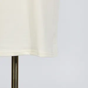 Detailed close-up showing the high-quality hemline stitching of the cream dress