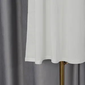 Close-up of the elegant white dress hem showing high-quality stitching and fabric texture.