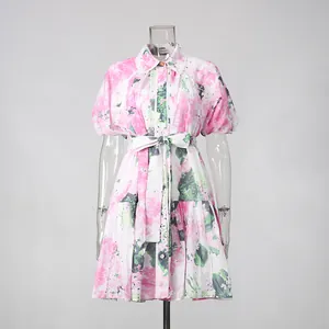 Detailansicht eines rosa geblümten Kleides mit Puffärmeln und verstellbarem Bindegürtel.