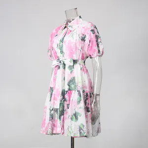 Nahaufnahme eines Kleides mit rosa-grünem Blumendruck, Puffärmeln und Bindegürtel