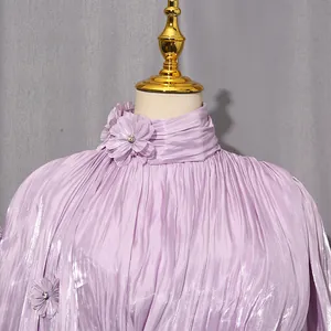 Macro detail of elegant lavender pleated dress featuring handcrafted floral crystal accents