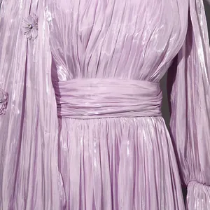 Detail of a lavender French style pleated maxi dress with shimmery fabric and floral accents.