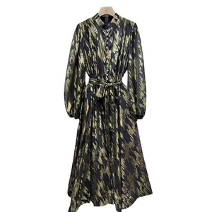 Full view of elegant black and gold metallic patterned long dress with tie-waist detail.