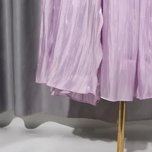 Close-up detail of the elegant lavender pleated dress hem with subtle shimmer texture