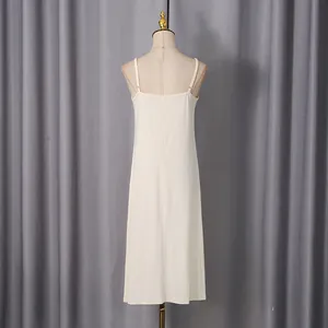 Elegant cream-colored minimalist long camisole slip dress shown from the rear on a mannequin