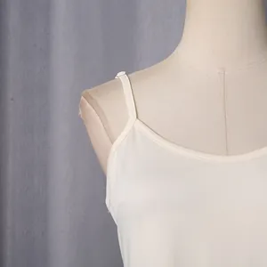 Close-up detail of cream camisole neckline and adjustable shoulder strap