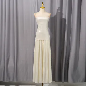 Detalle de vestido blanco palabra de honor con lentejuelas y falda plisada