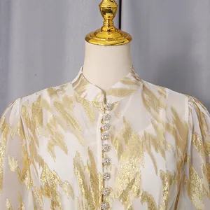Close-up of elegant dress featuring a mandarin collar and sparkling rhinestone buttons.