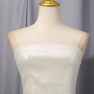 Vista detallada de la tela de lentejuelas blancas y costuras de malla en vestido