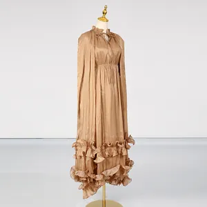 Elegant metallic gold long dress with ruffles and a cape-like design in detail view