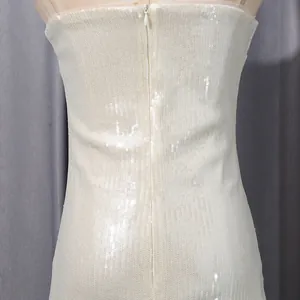 Detalle de textura de lentejuelas blancas y cremallera oculta en vestido de playa