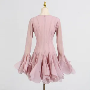 Vista trasera detallada del vestido rosa con volantes, dobladillo y mangas largas