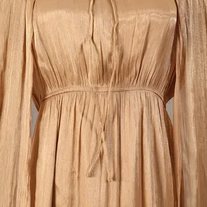 Detail view of champagne pleated dress with elasticated waist and tie strings