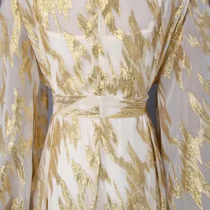 Close-up detail of elegant white long dress with abstract gold foil flame patterns