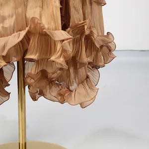 Close-up view of elegant golden tiered ruffles on a luxury fashion evening dress hemline
